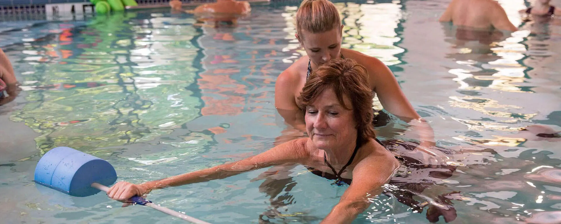 Therapist Helping Elderly to Swim
